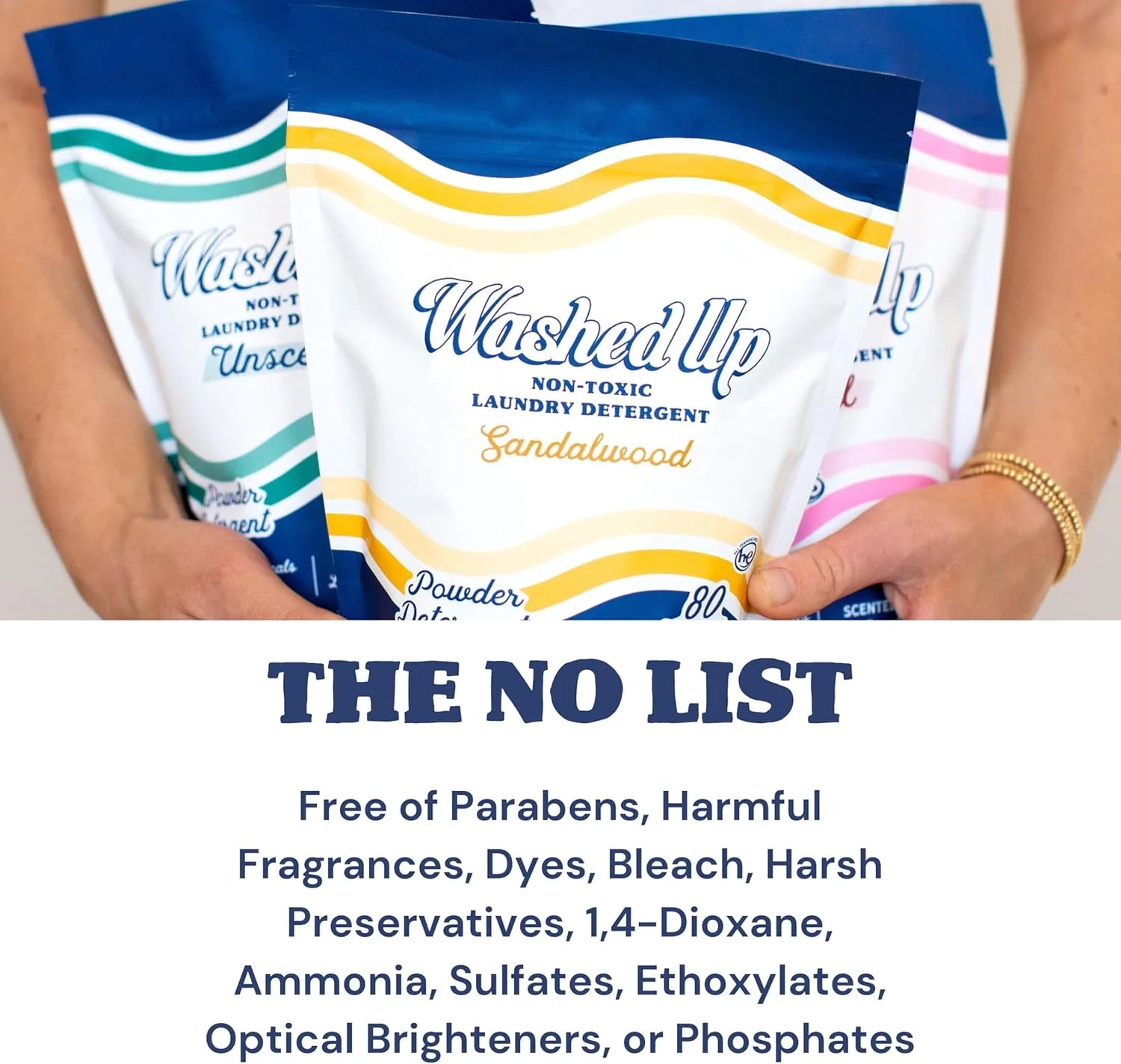 Three colorful bags of "Washed Up" laundry detergent are held by a person. Labels read "Unscented," "Sandalwood," and include a "No List" of harmful chemicals.